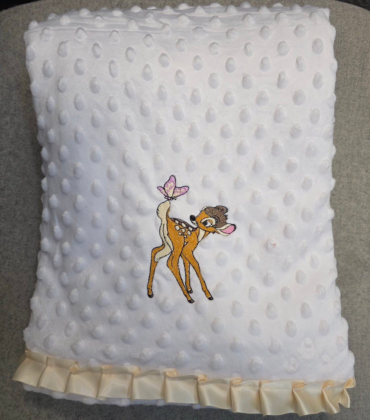 Matching folded baby deer blanket in white dimple fleece
